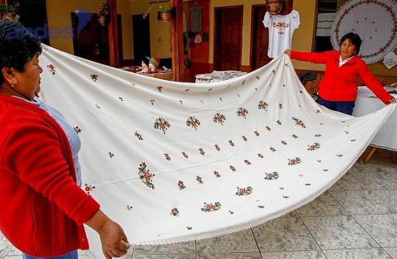 Les femmes montrent une nappe brodée main